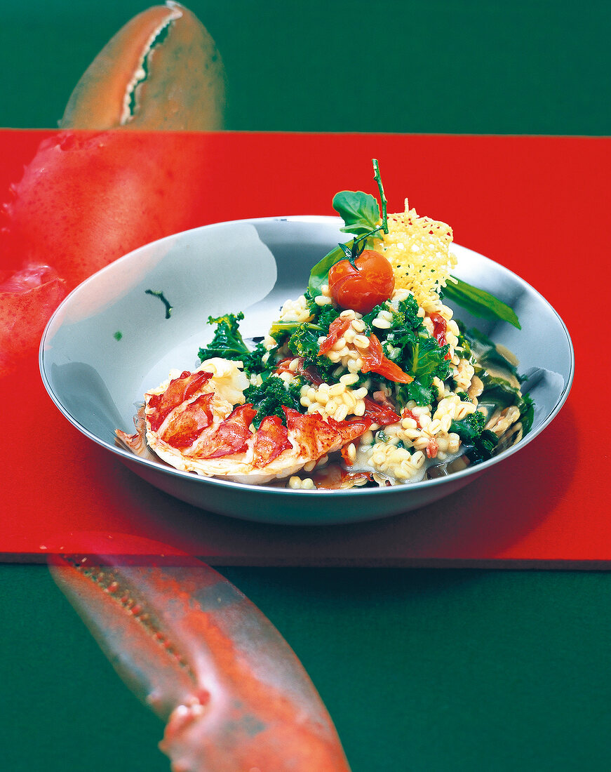 Barley risotto with green cabbage and fried lobster medallions on plate