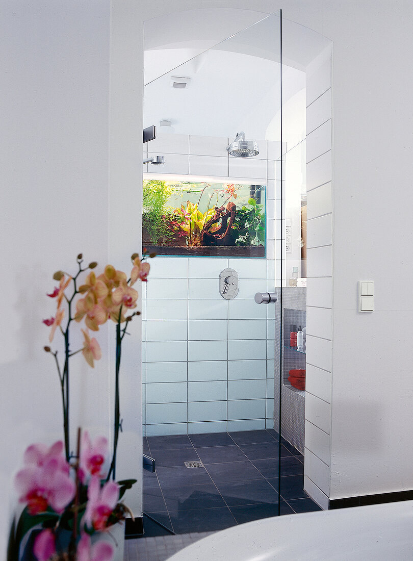 Bathroom with white tiles, shower and integrated aquarium