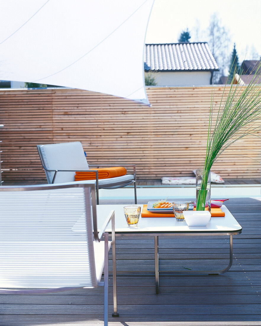 Wooden terrace with chairs and small table