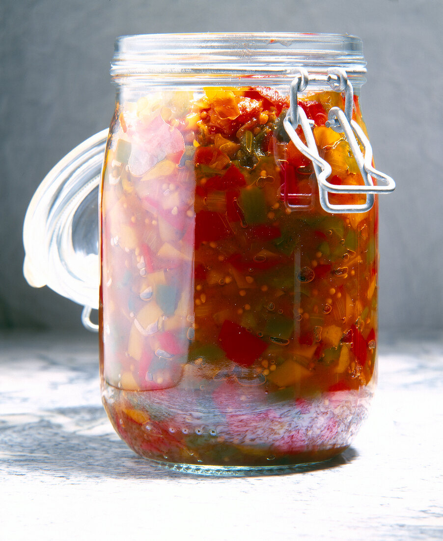 Spicy chutney with colorful peppers in glass jar