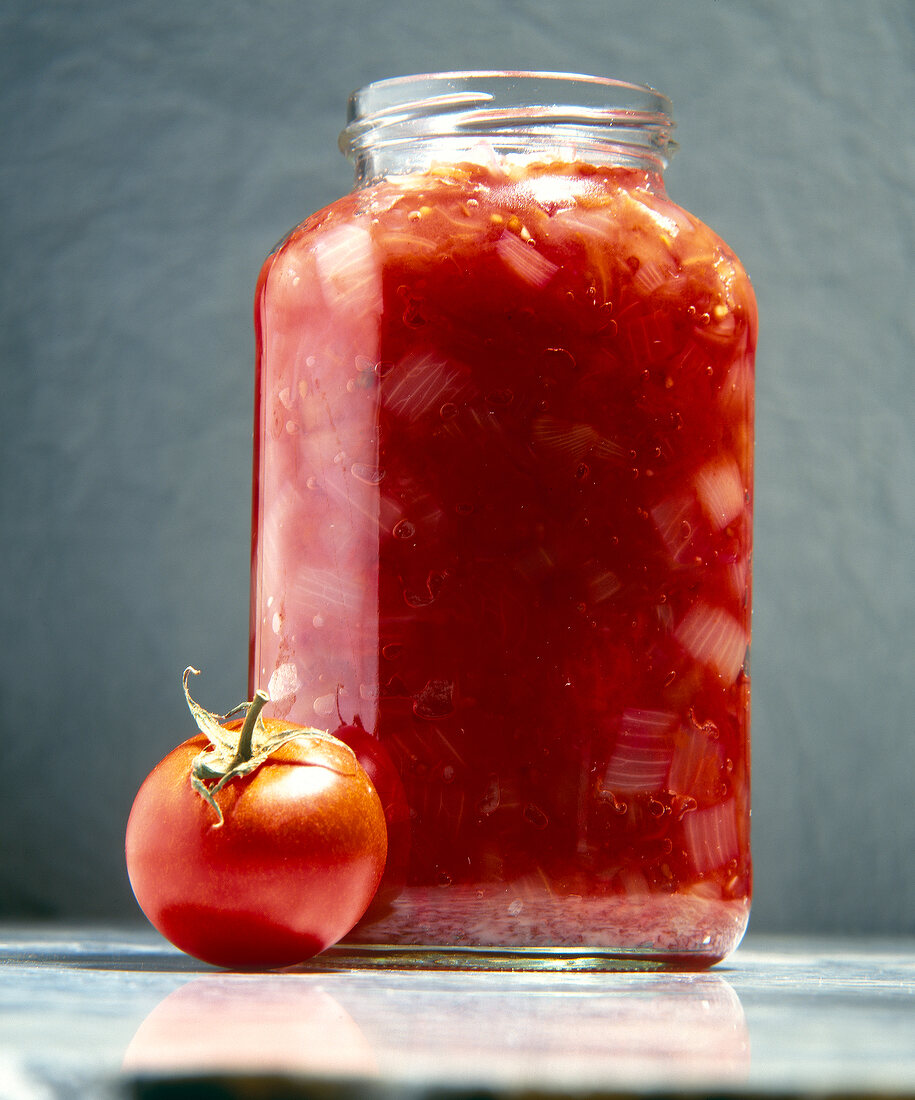 Spicy chutney with tomatoes and onions in glass jar