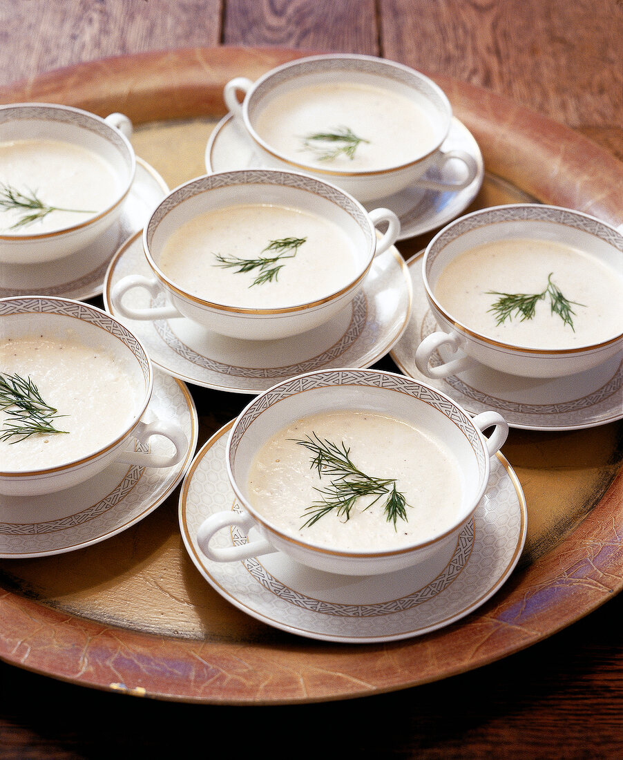 Trout soup garnished with herbs in cups