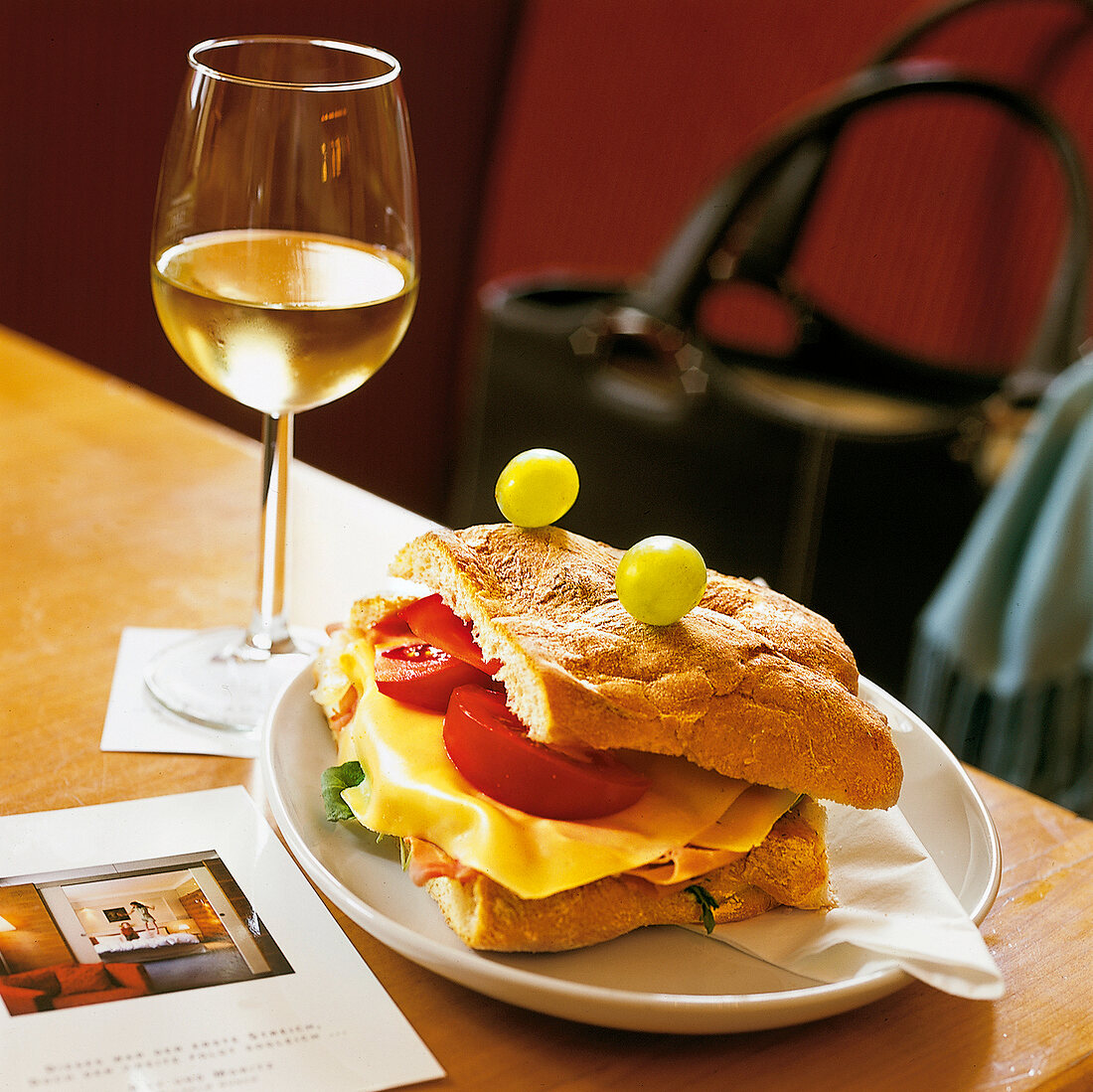 herzhaftes Sandwich mit Käse und Schinken, dazu Weißwein im Auersperg