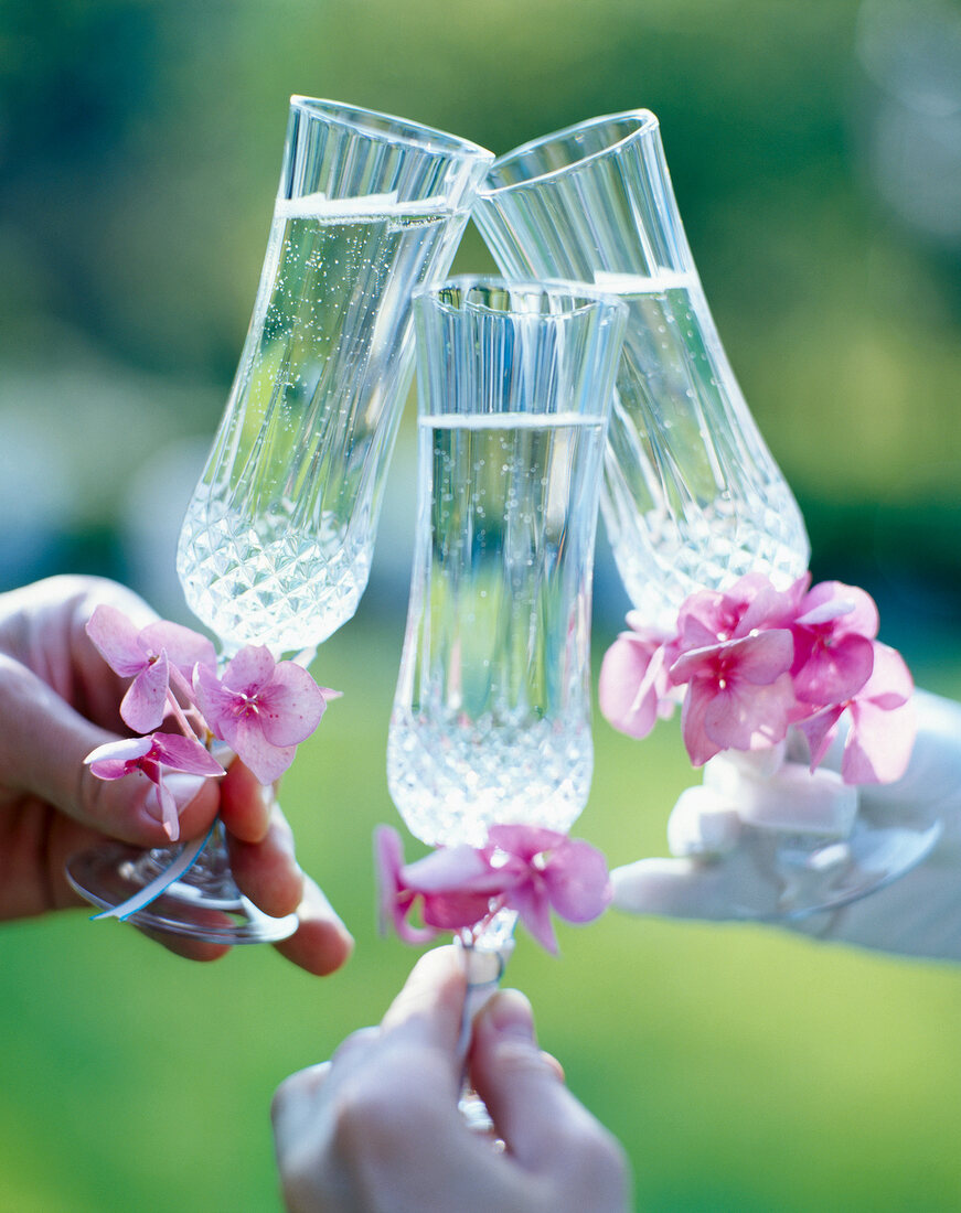Close-up of three champagne goblets with flowers