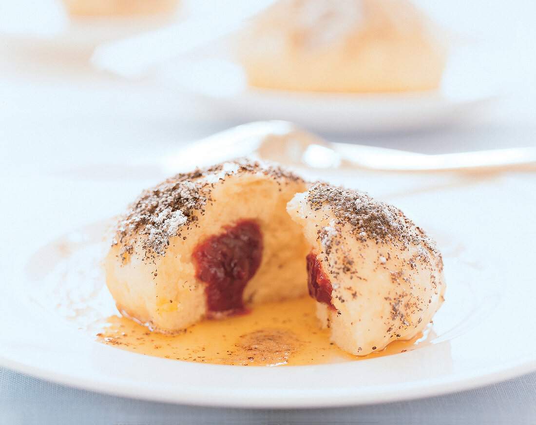 Germknödel mit Mohnzucker auf einem weißen Teller, Detail