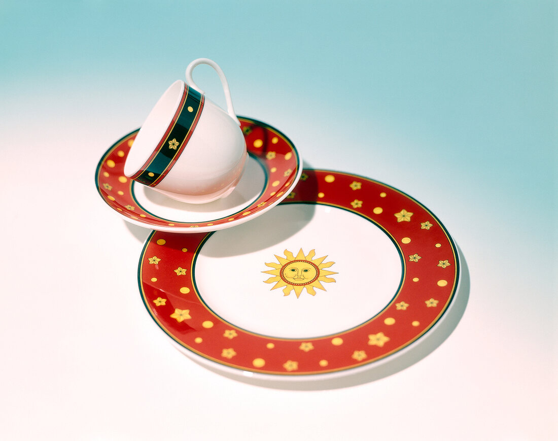 Cup with saucer and plate on blue background