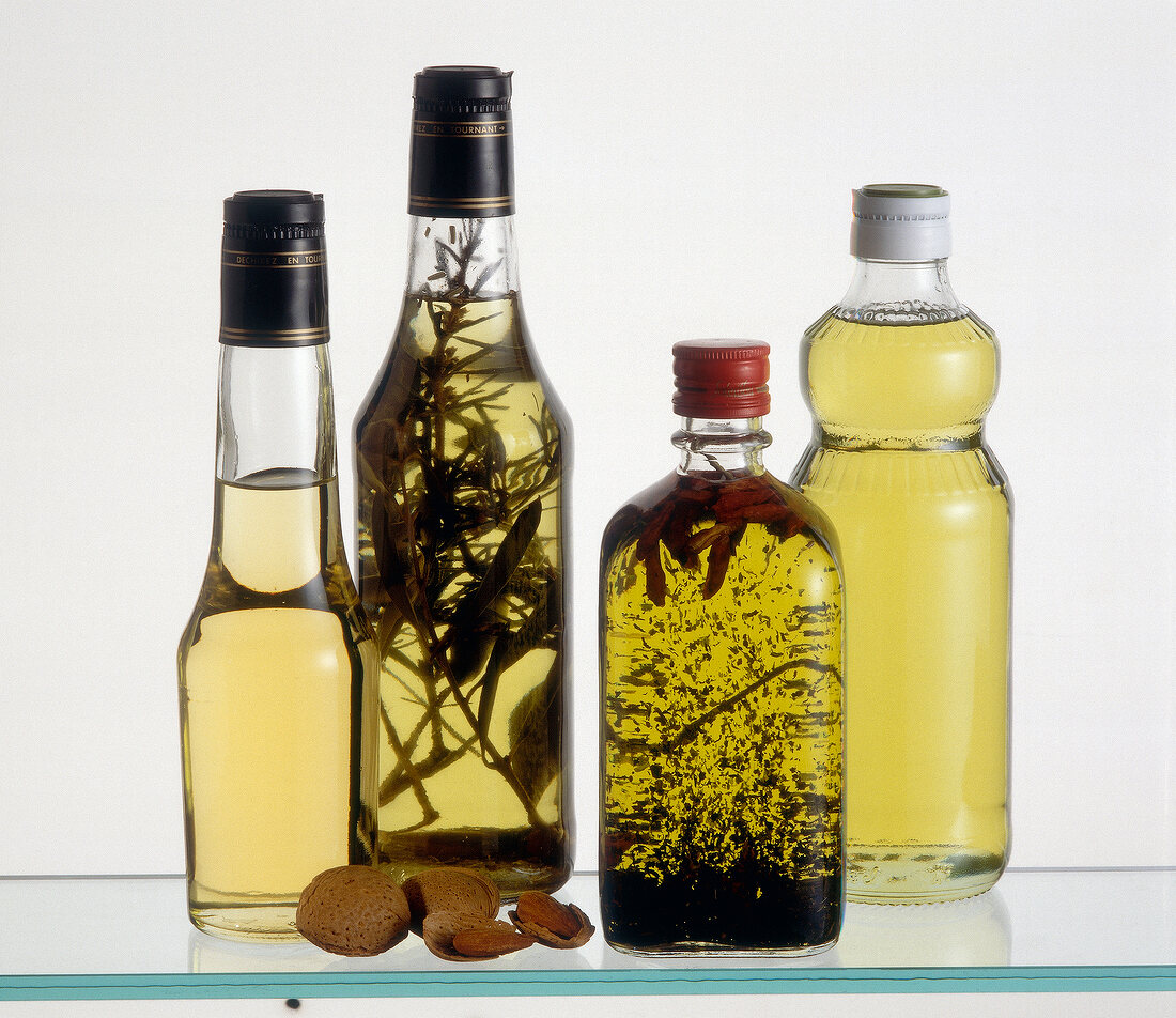 Different types of oils in glass bottles on white background