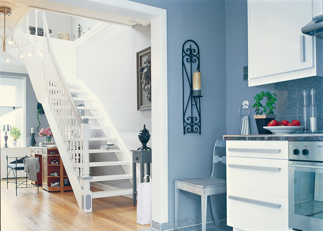 Geschwungene weiße Treppe fürht zum Dachstuhl in Maisonettewohnung