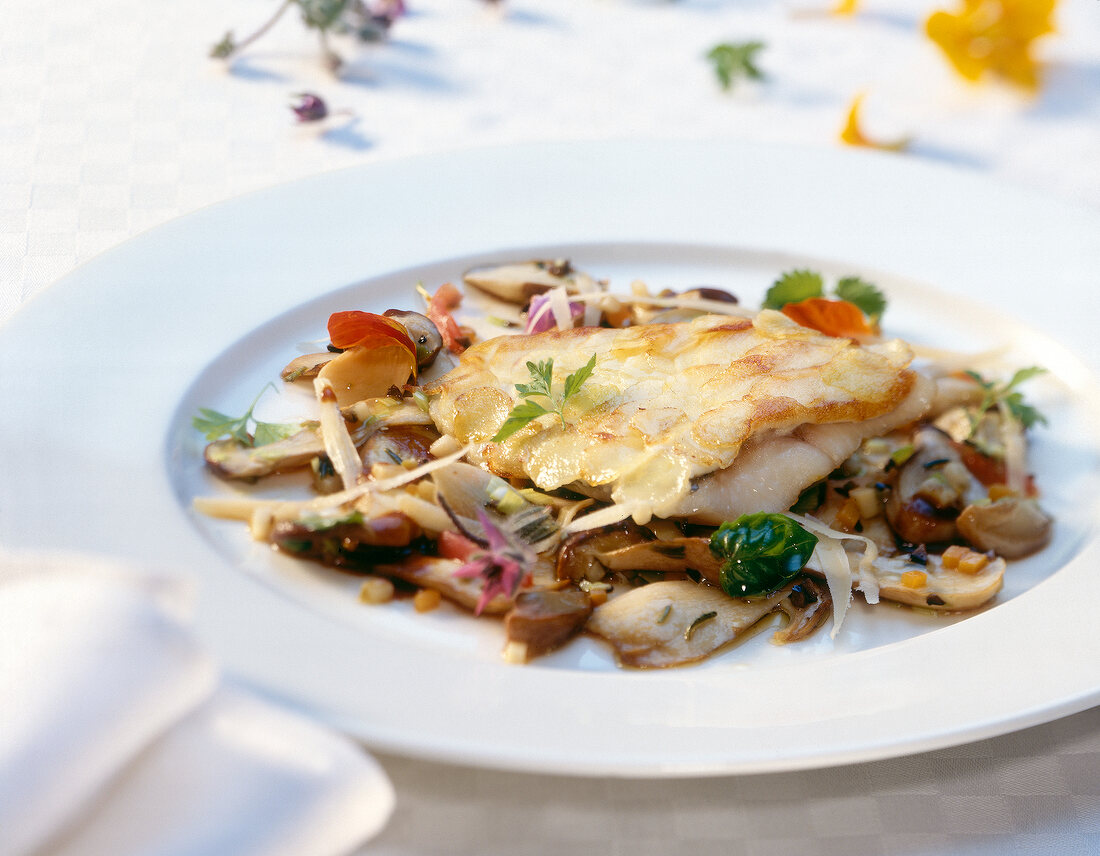 Perch fillet with potato flakes and marinated mushrooms on plate