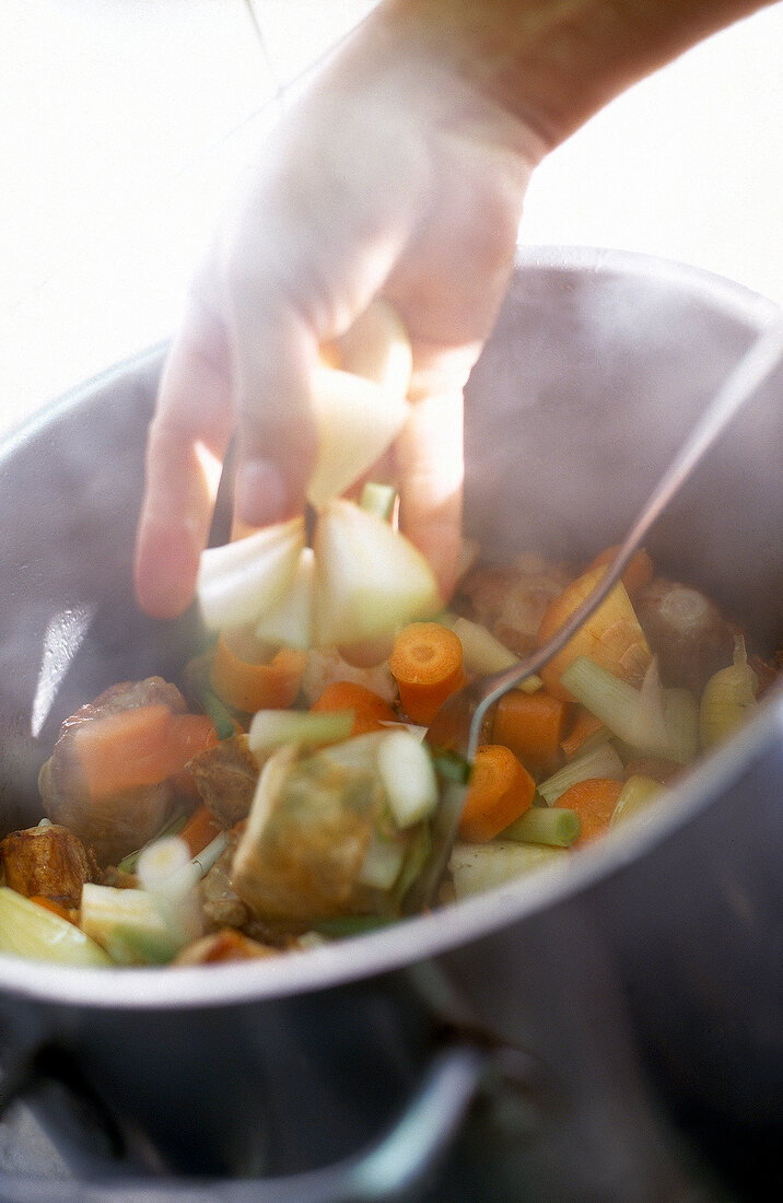 Röstgemüse und Kalbsschwanz werden angebraten