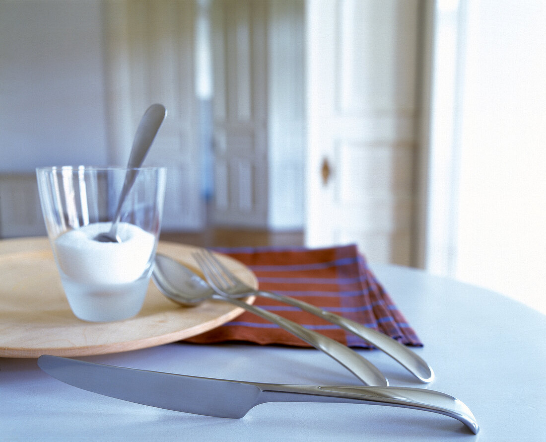Designer cutlery on wooden plate