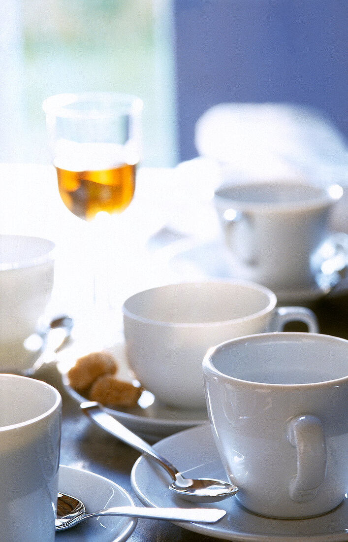 Various coffee cups with spoons on table