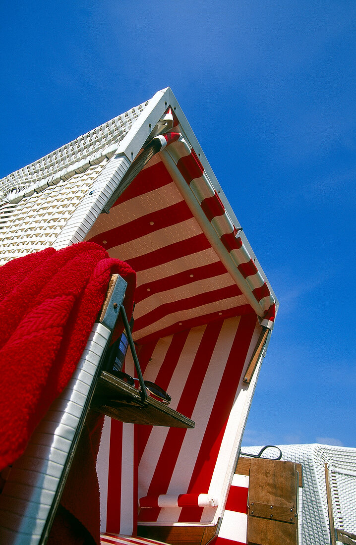Low angle view of red and white striped beach chair