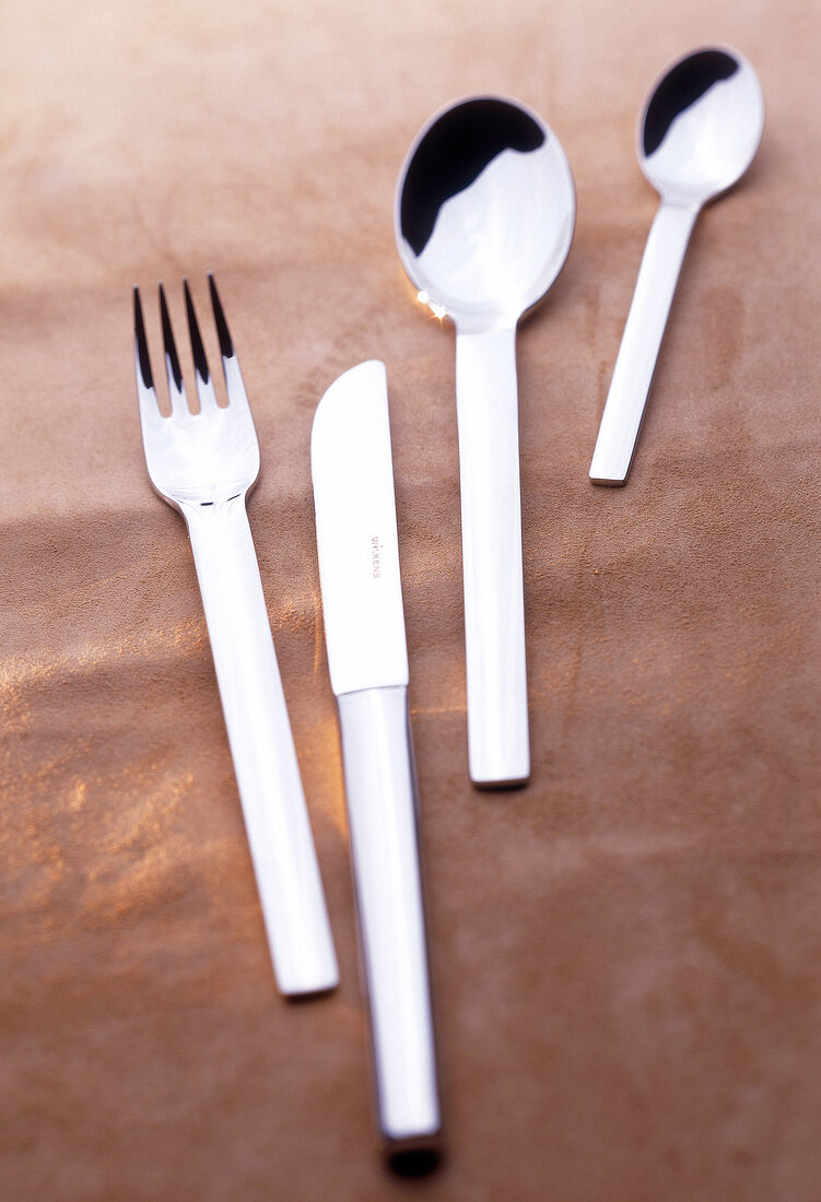Classic stainless steel cutlery on brown background