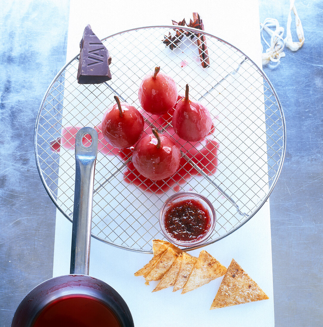 Poached pears with sauce, chocolate and nacho chips on grill