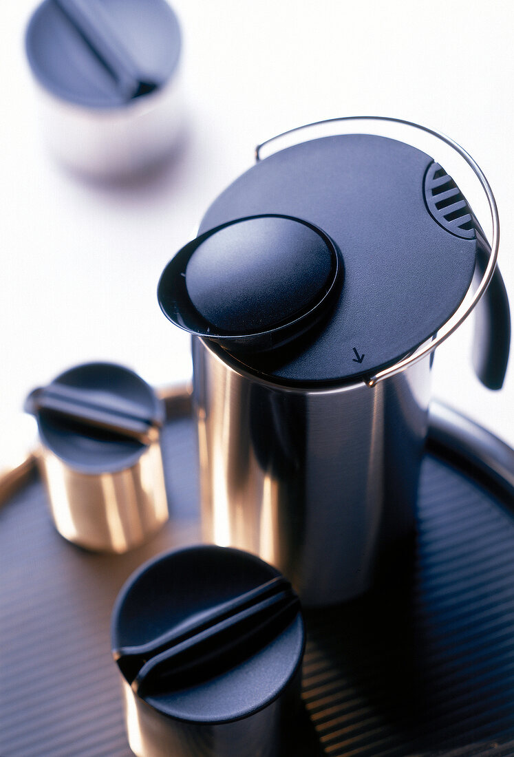 Close-up of thermos with stock cans on tray