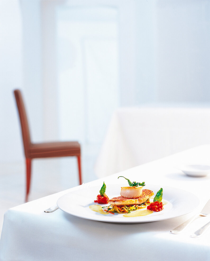 Salad of vegetables with grilled red mullet and fish stew on plate