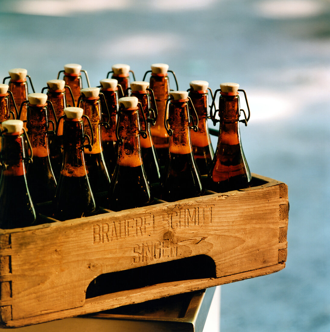 Close-up of flip top beer bottles in a wooden crate