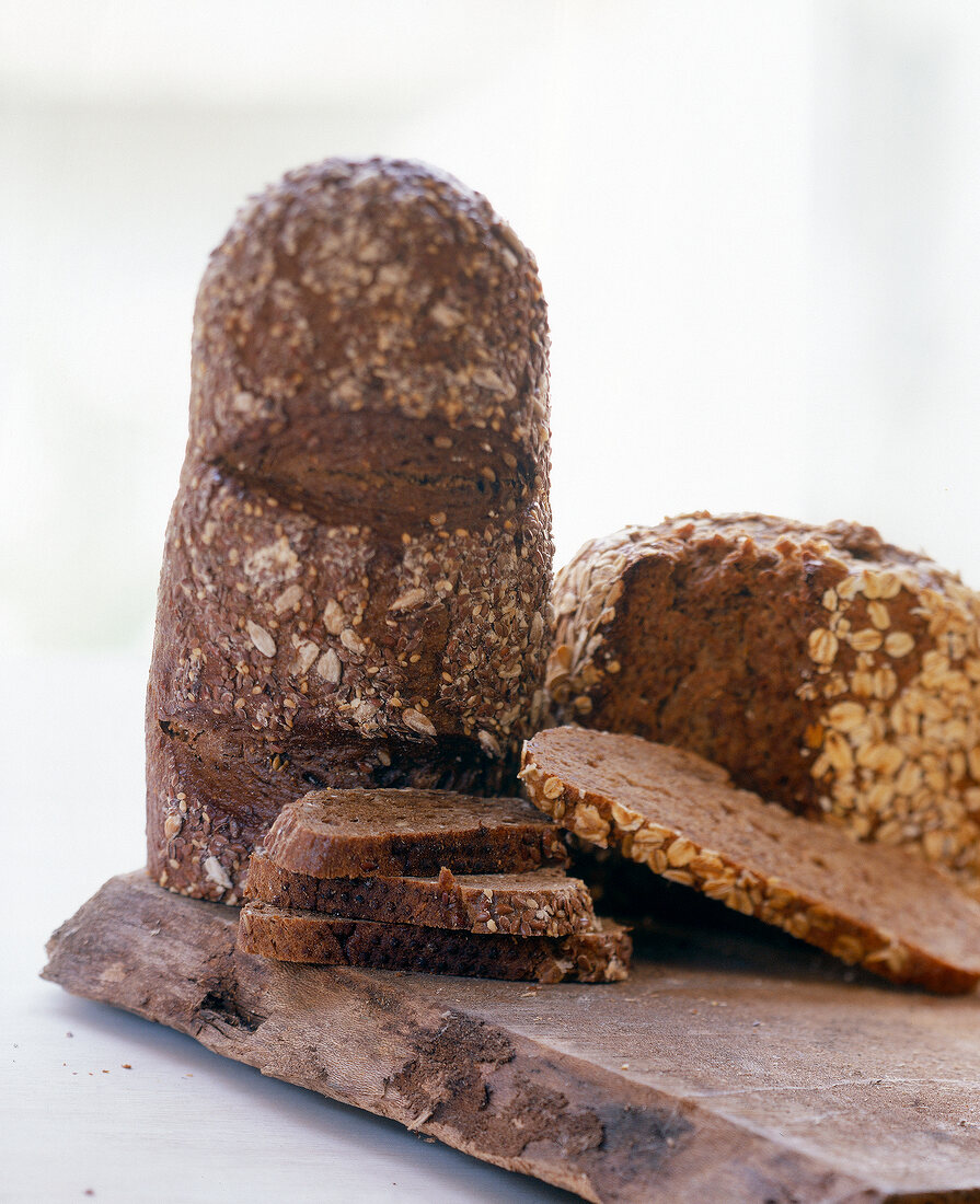 Close-up of dark wholegrain rye bread with oatmeal, loaf and slices