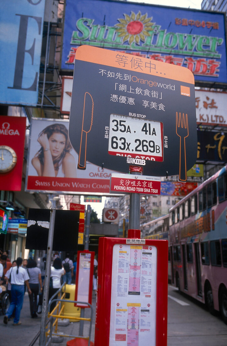 Die belebte Nathan Road in Kowloon mit Reklametafeln im Vordergrund