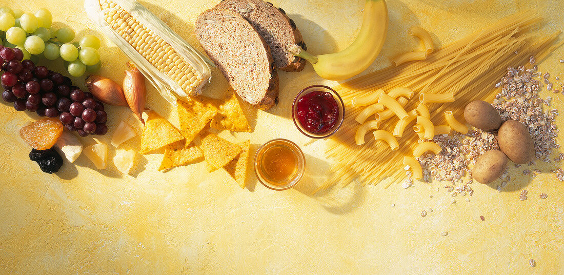 Various carbohydrate rich food like pasta, corn and bread, egg and grapes