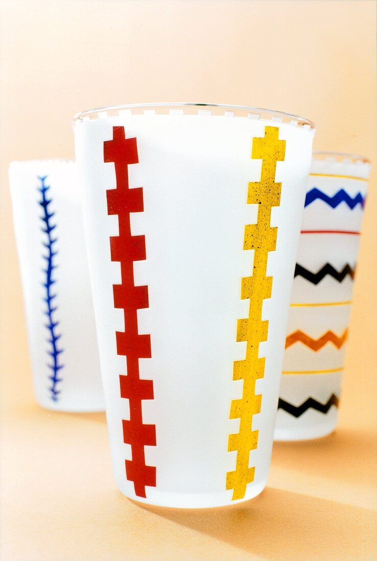 Close-up of water and juice glasses with muilt-coloured pattern
