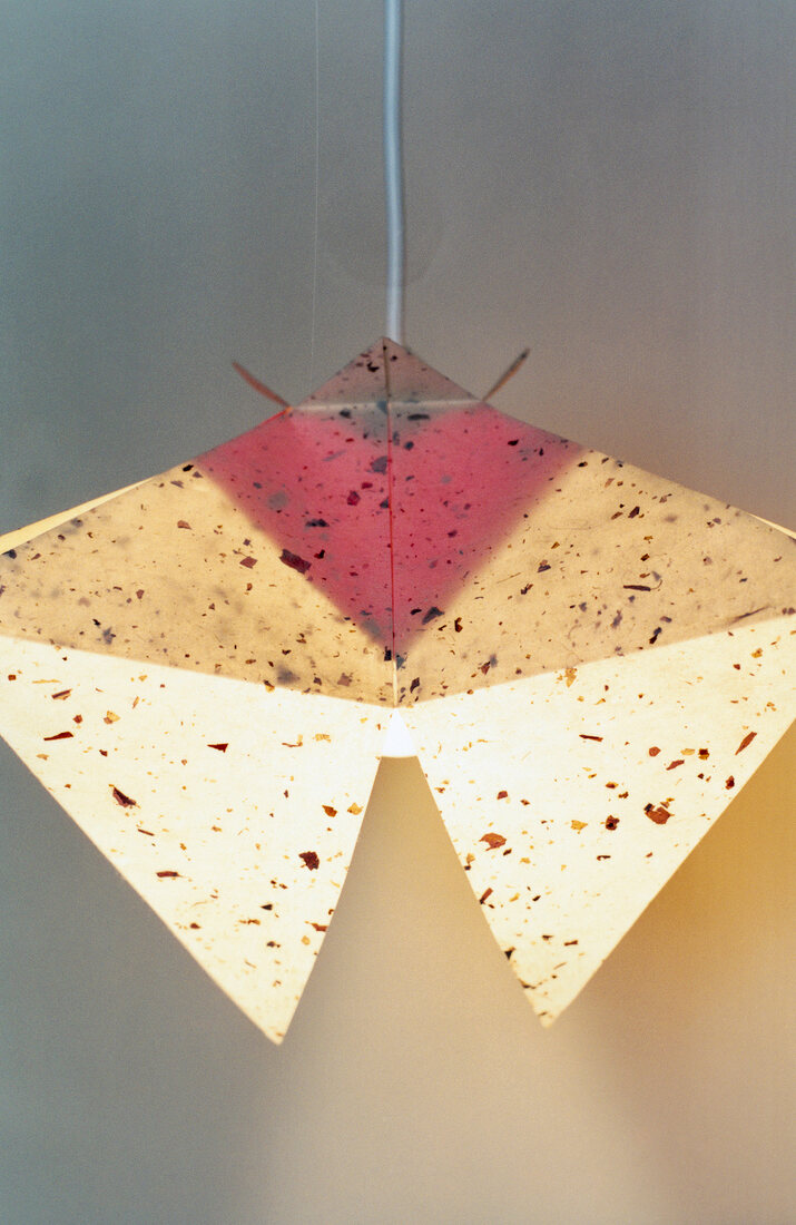 Colourful paper lamp hanging on white background
