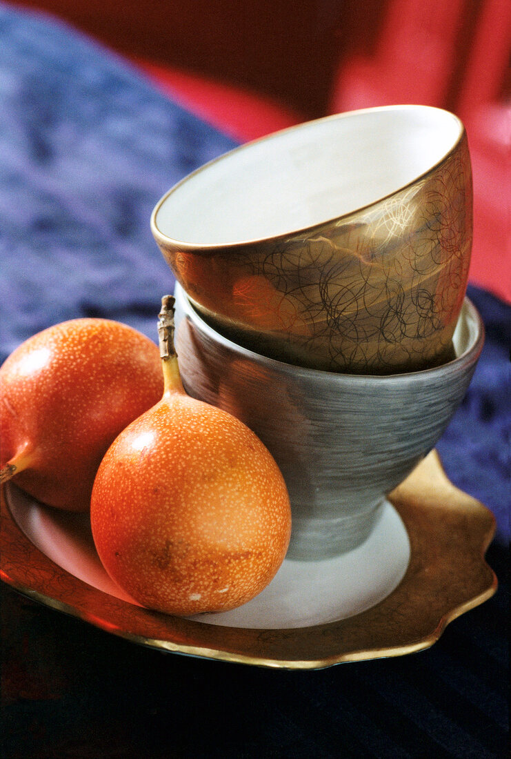 Close-up of fruits and porcelain bowls with gold and platinum coating on plate