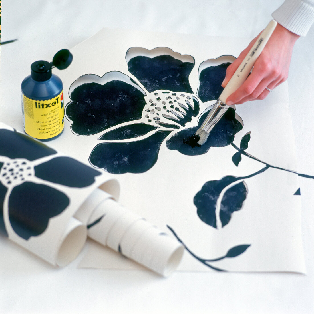 Painting with brush and ink on curtain using stencil