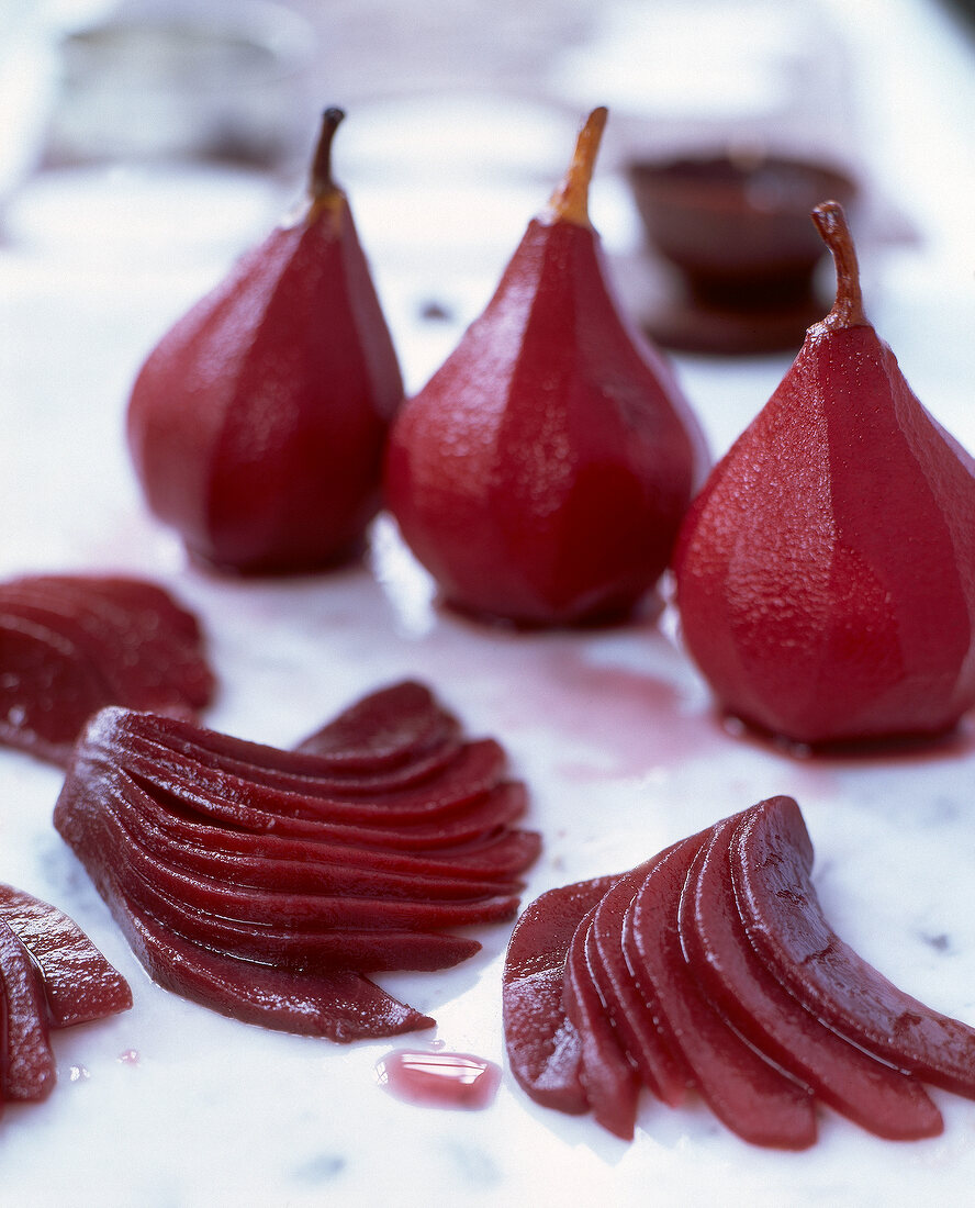 Whole and sliced pears in red wine
