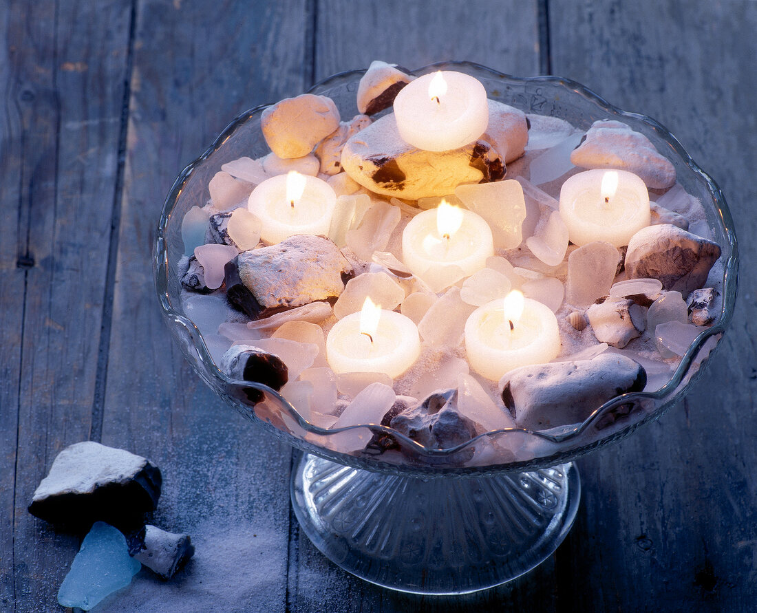 Tea light candles with pebbles and sand in bowl