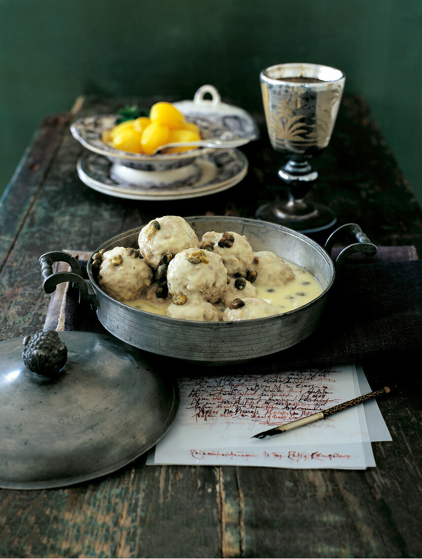 Meatballs with white sauce and capers in casserole