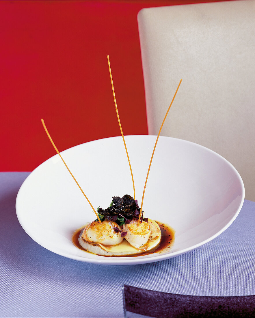 Fried scallops with black perigord truffle in white bowl