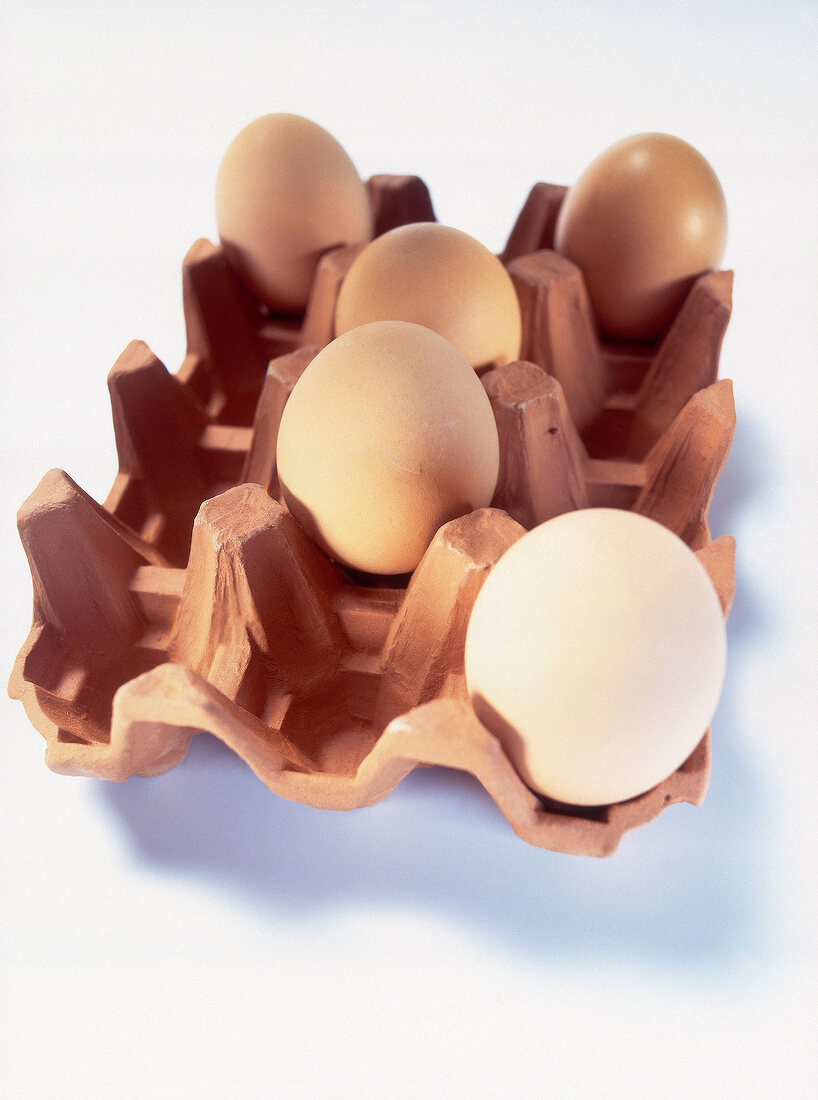 Rustic terracotta egg carton with brown eggs