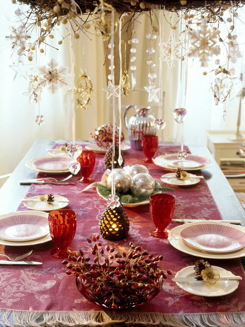 Banquet table set festively with pearl necklaces hanging above