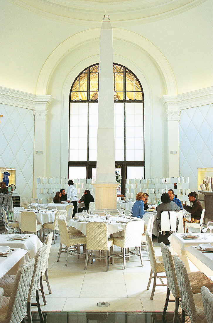 People sitting in the design restaurant Euro show in white tones at Los Angeles, USA