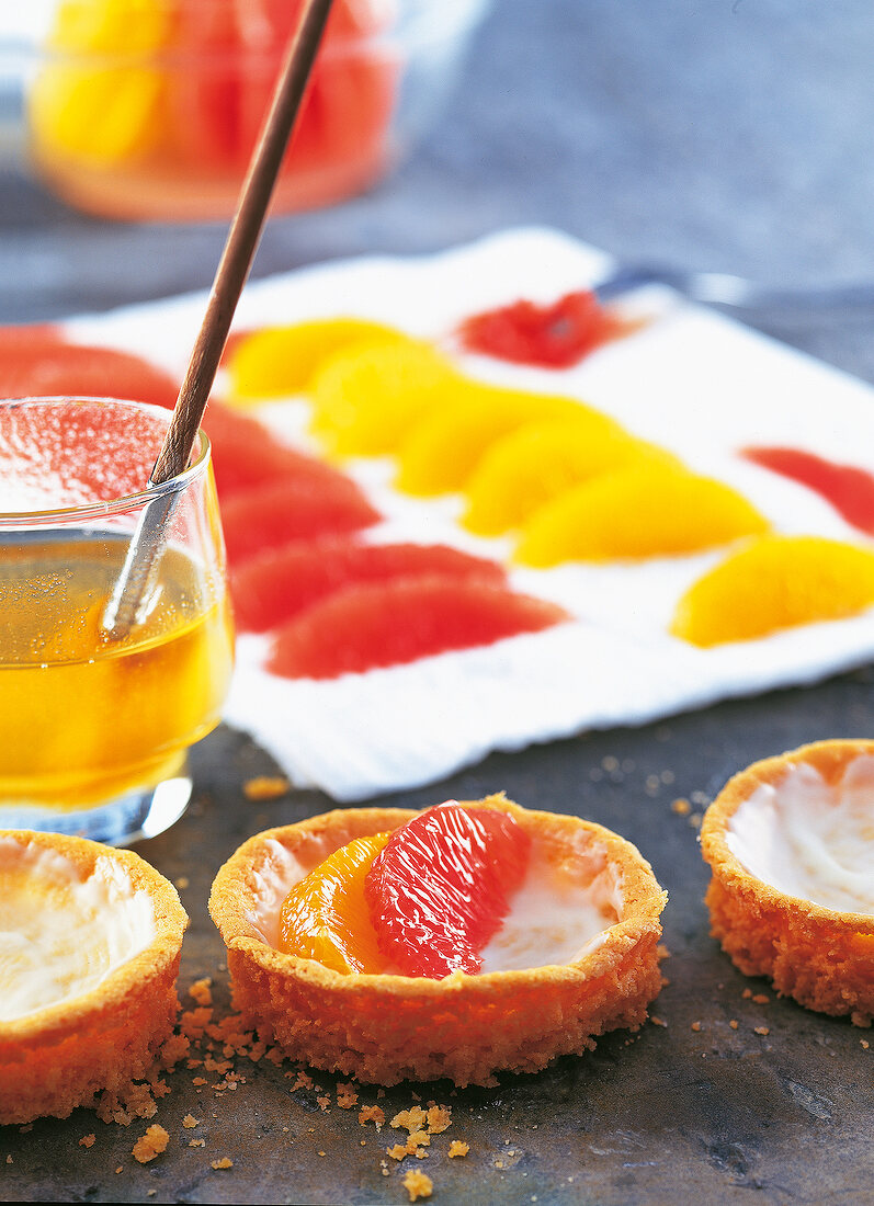 Grapefruit und Orangen, Scheibchen werden auf den Mürbeteig gelegt