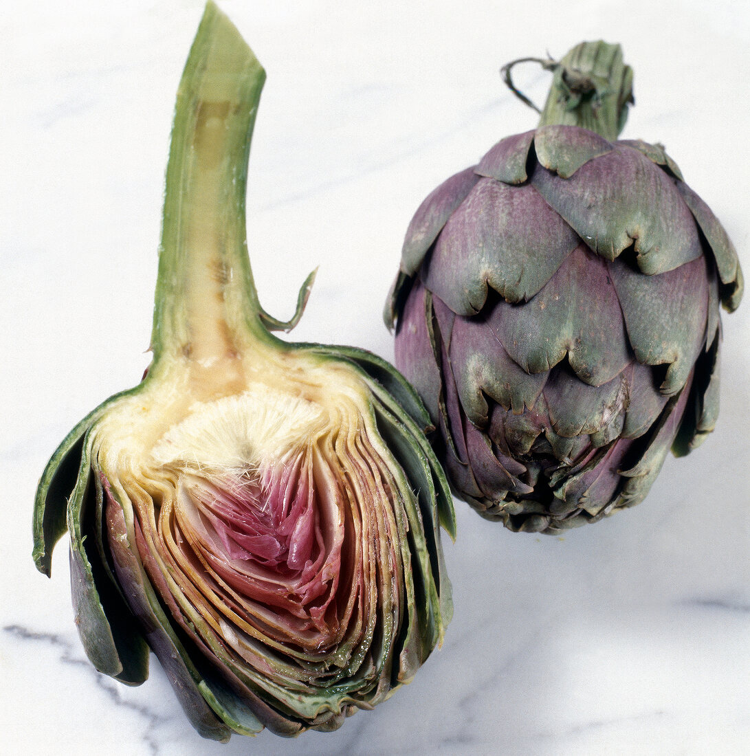 Close-up of whole and halved artichokes