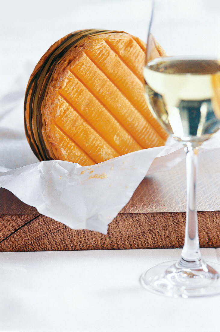 Close-up of raw livarot cheese with glass of white wine