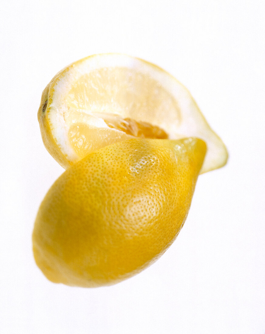 Close-up of whole and halved lemon on white background