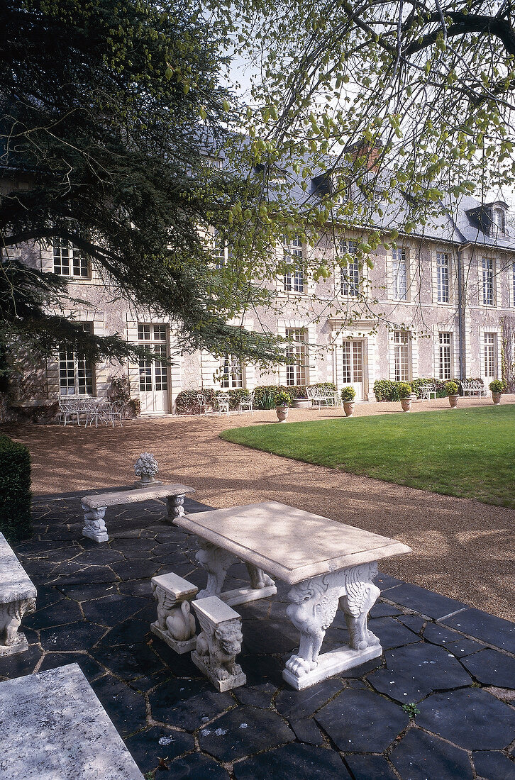 Stone table and bench in park of Chateau De Noirieux Hotel, Briollay, France