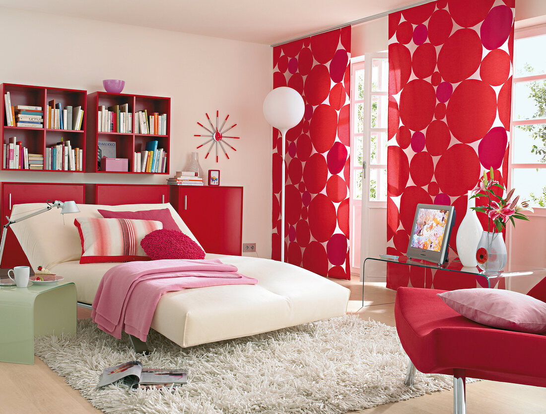 Room with white bed, fur carpet and red curtains