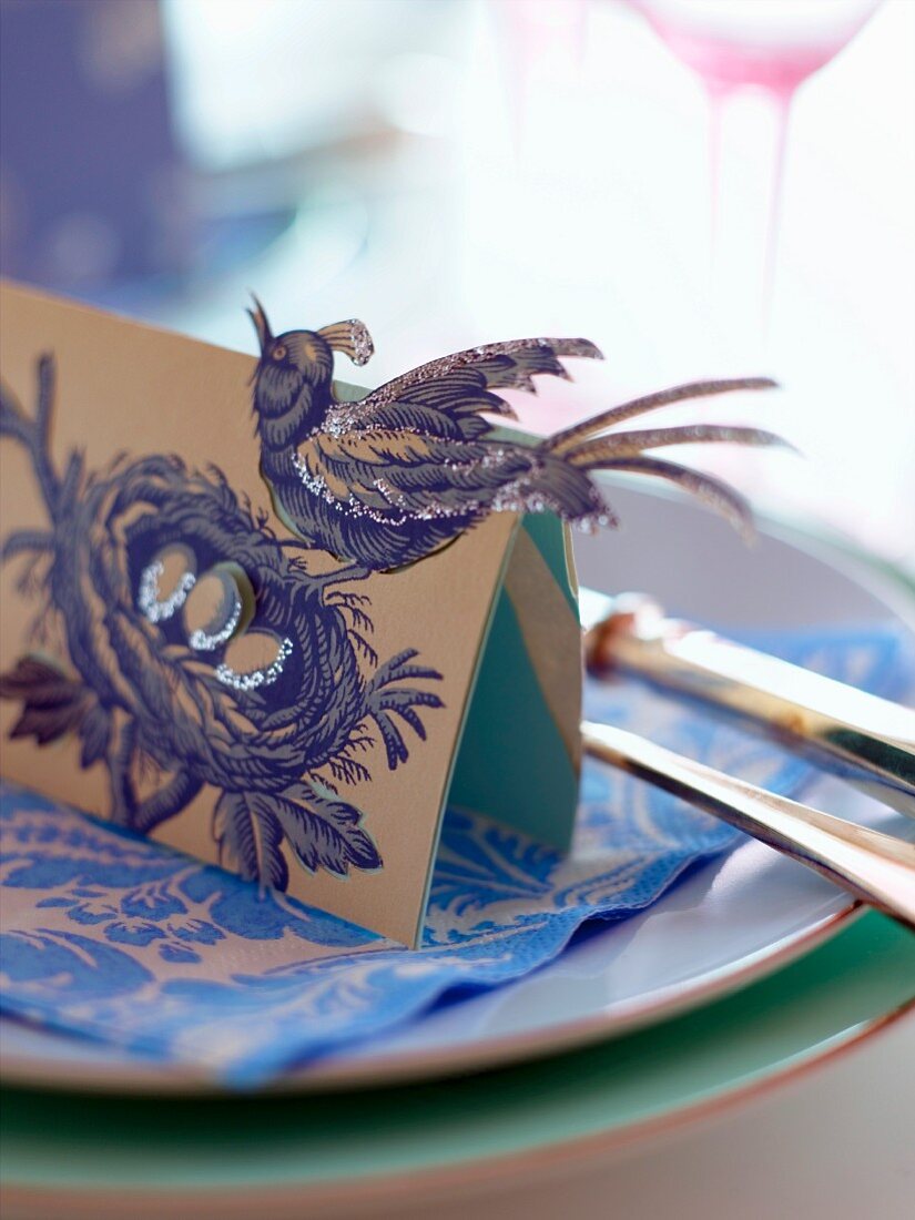 Place card with bird motif on plate