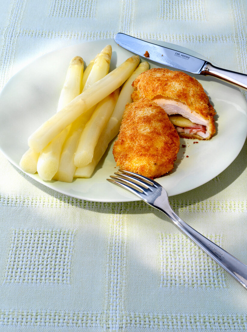 Asparagus and chicken cordon bleu with ham and cheese on plate
