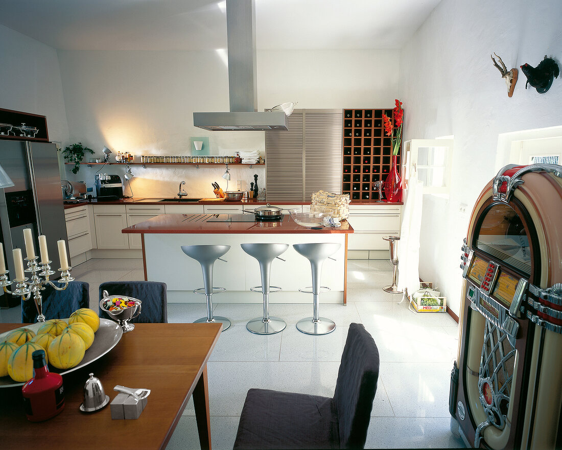 Kitchen with three bar stools, jukebox and dining area