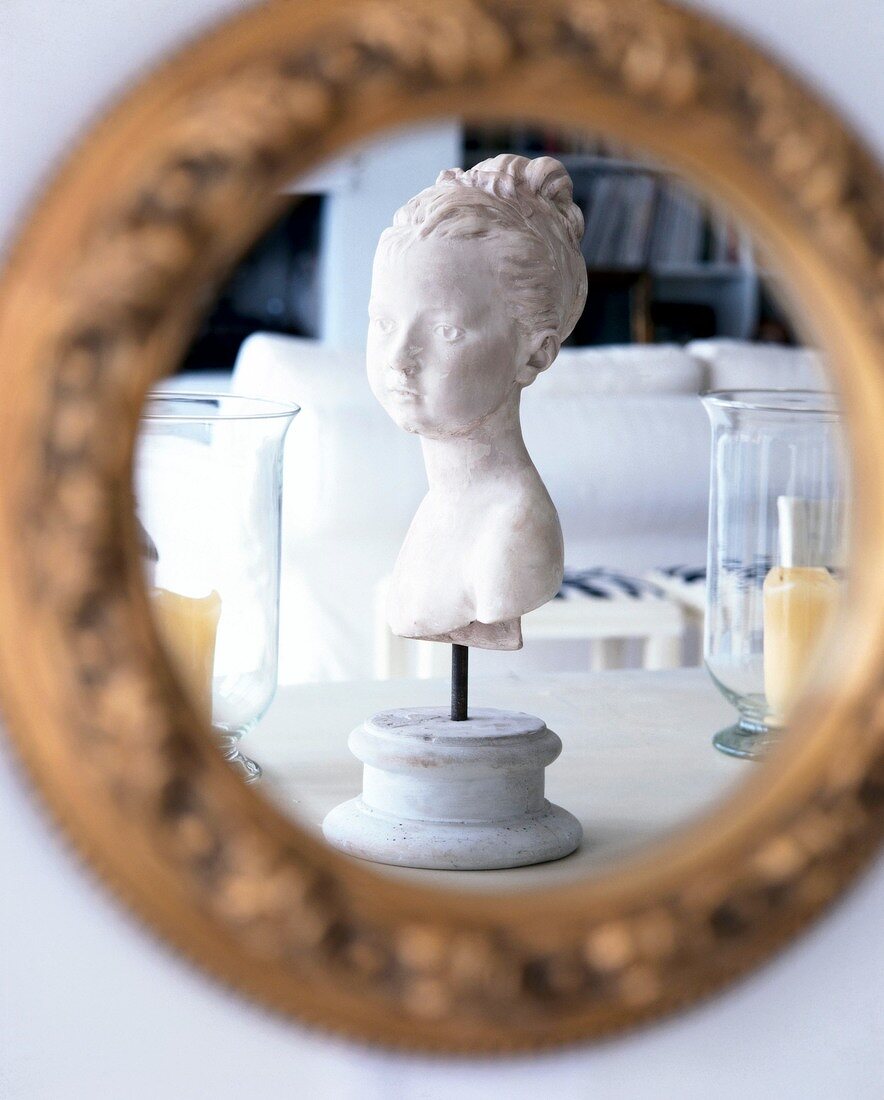 Bust of a child made from gypsum against mirror