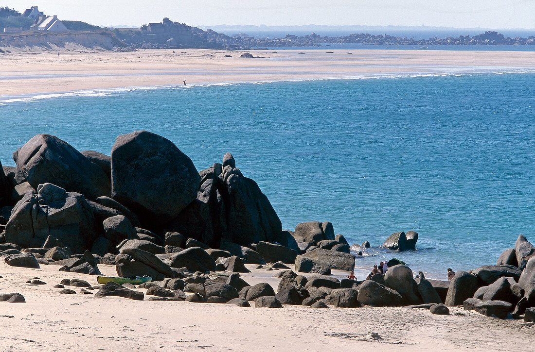Blick über Felsgestein auf Bucht und Strand bei Cleder, Bretagne
