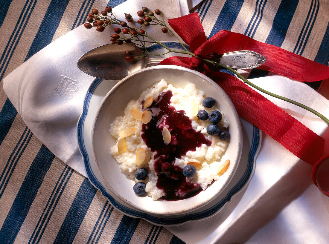 Cream and almond rice with blueberry sauce on plate