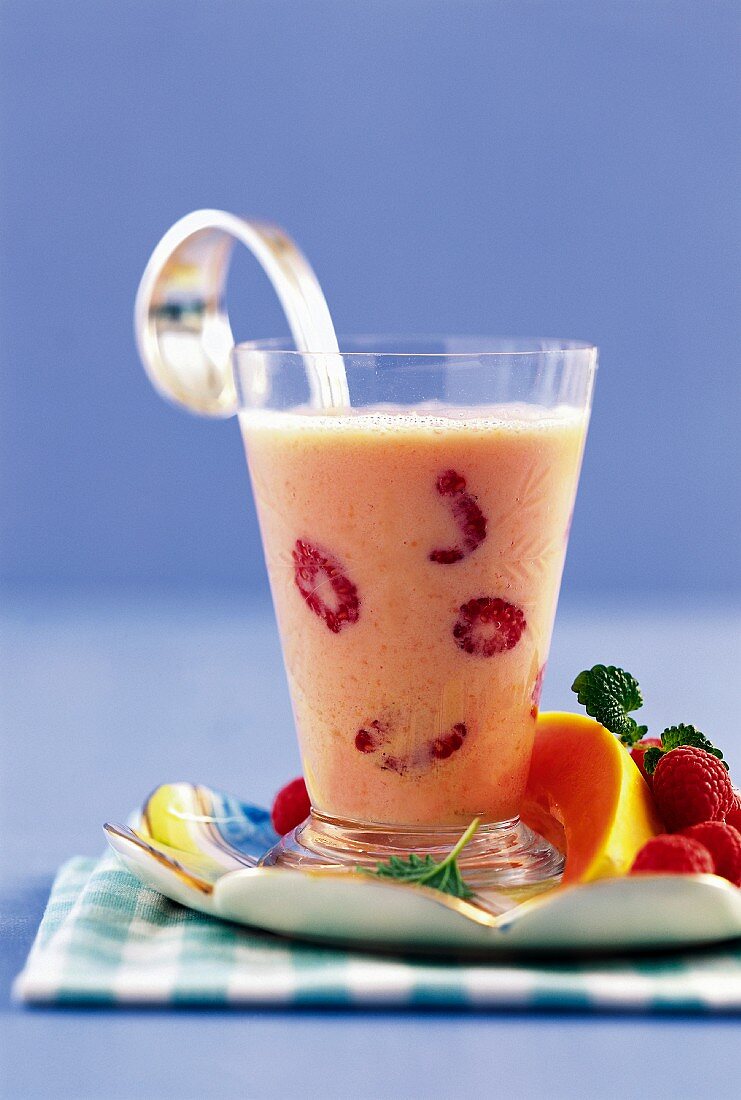 A drink made with yogurt, papaya and raspberries
