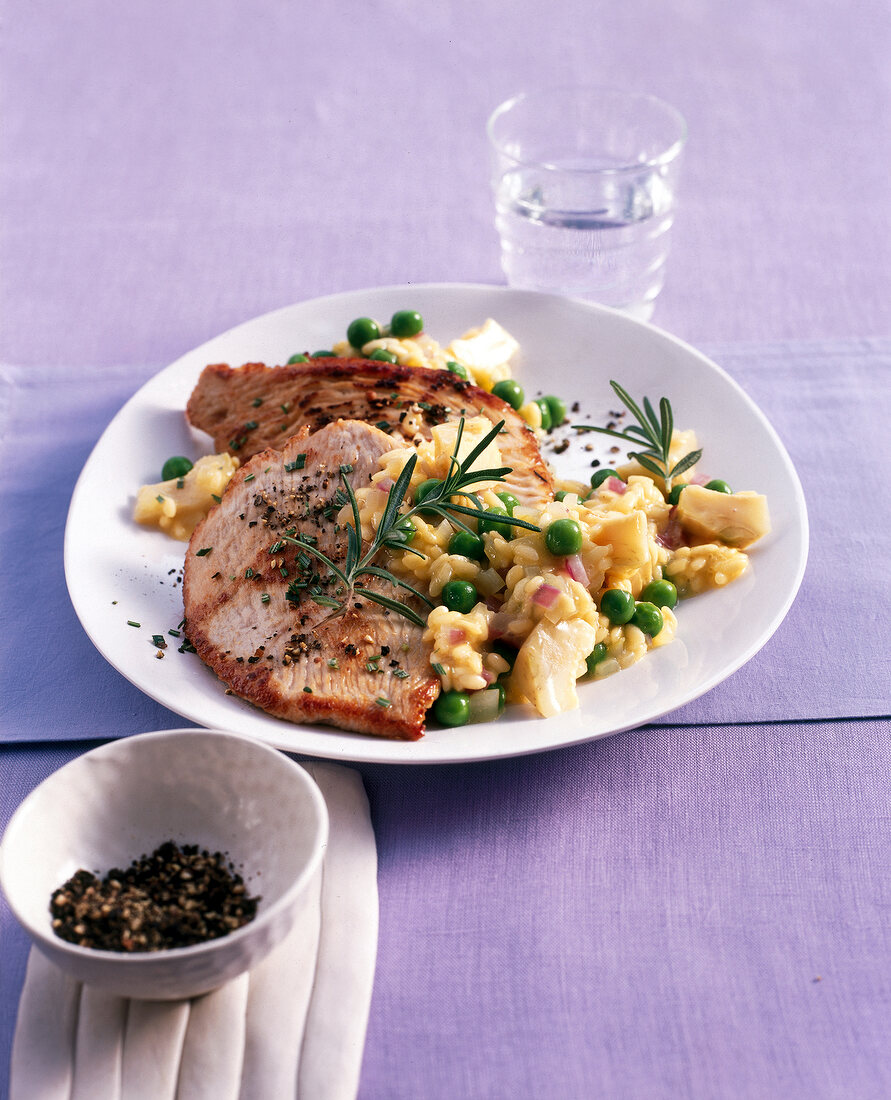 Turkey cutlets with artichoke risotto on plate